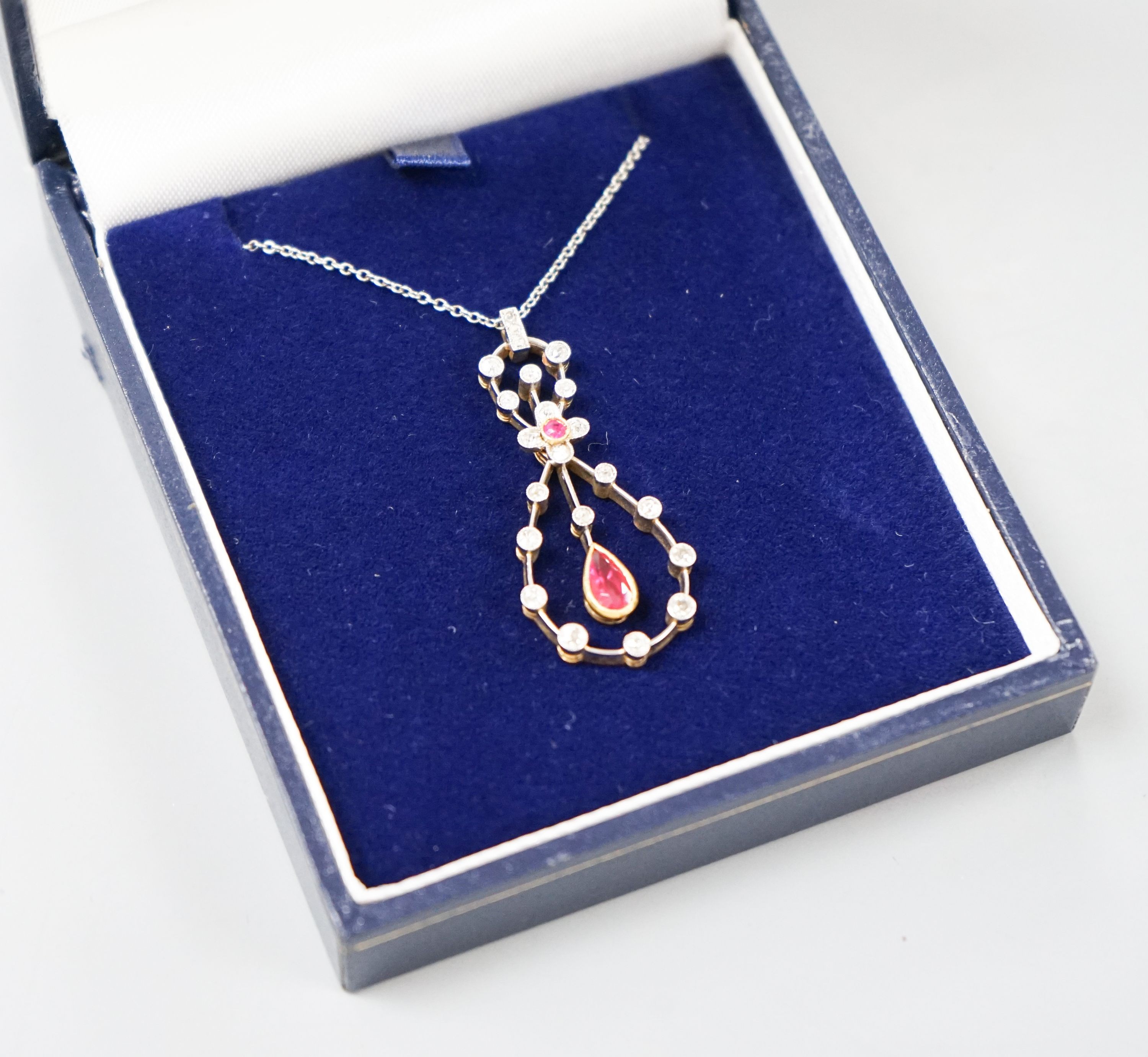 A modern 1920's style white metal, ruby and diamond set openwork oval drop pendant necklace, pendant 37mm, gross weight 6.1 grams.